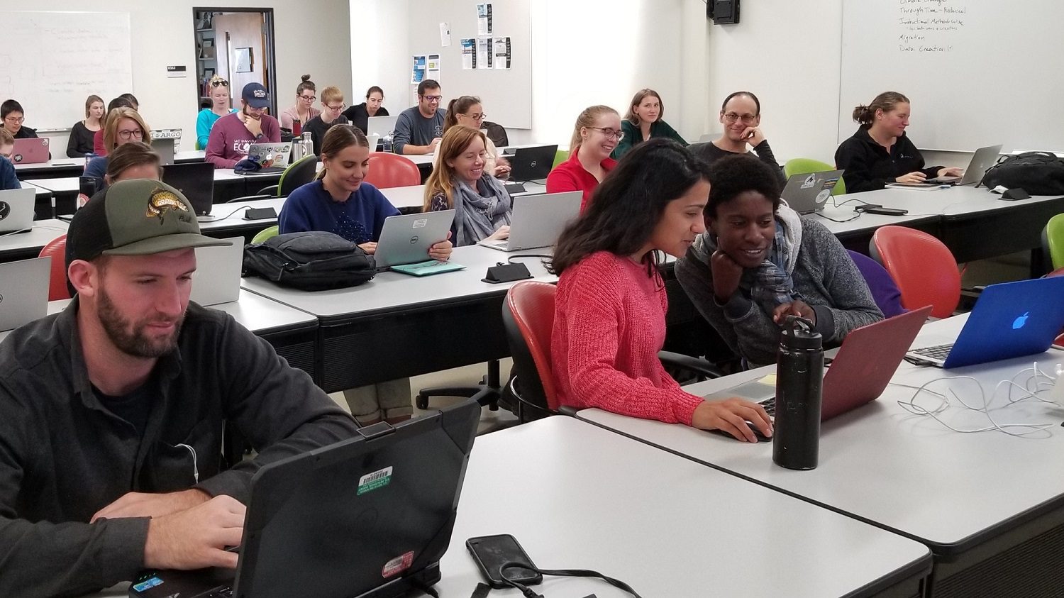 Participants in a DataLab event work individually or in small groups at laptops